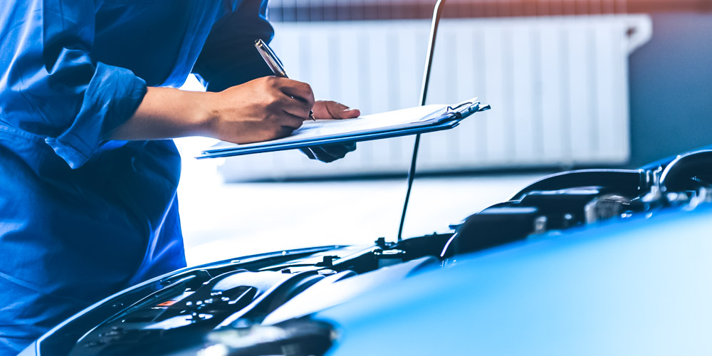 Mechanic fixing car with hood open.